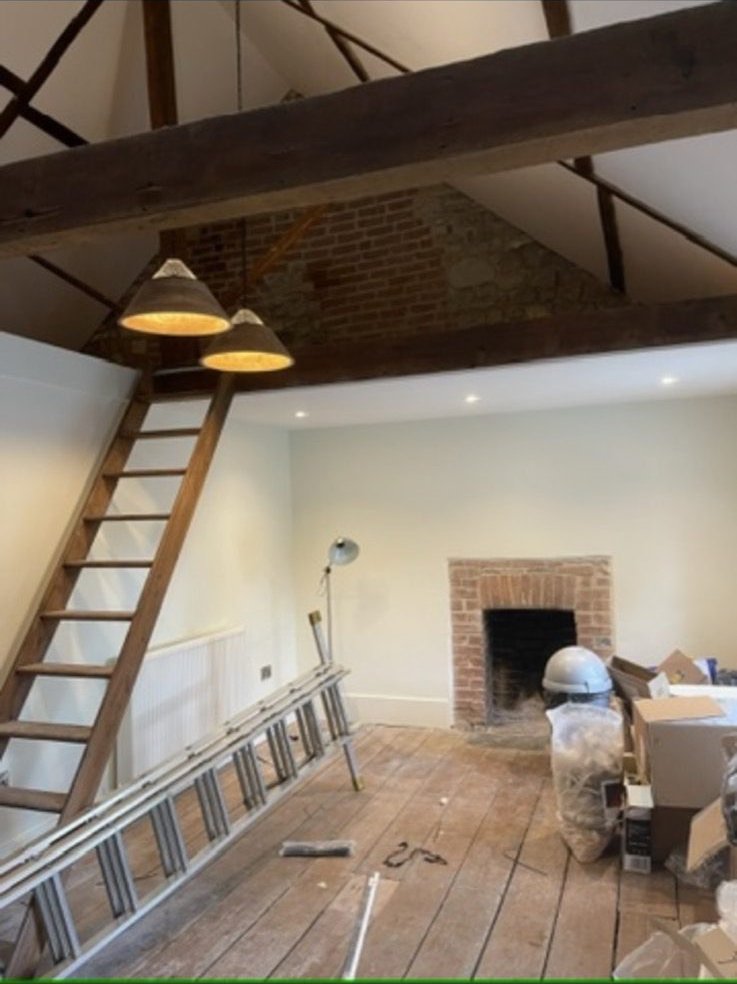 Interior of a converted stone barn showing exposed stone walls and concealed wiring