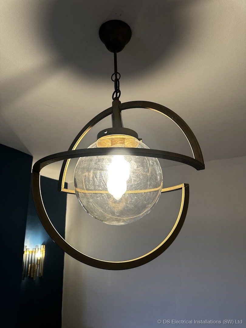 Caged glass globe pendant light installed and wired