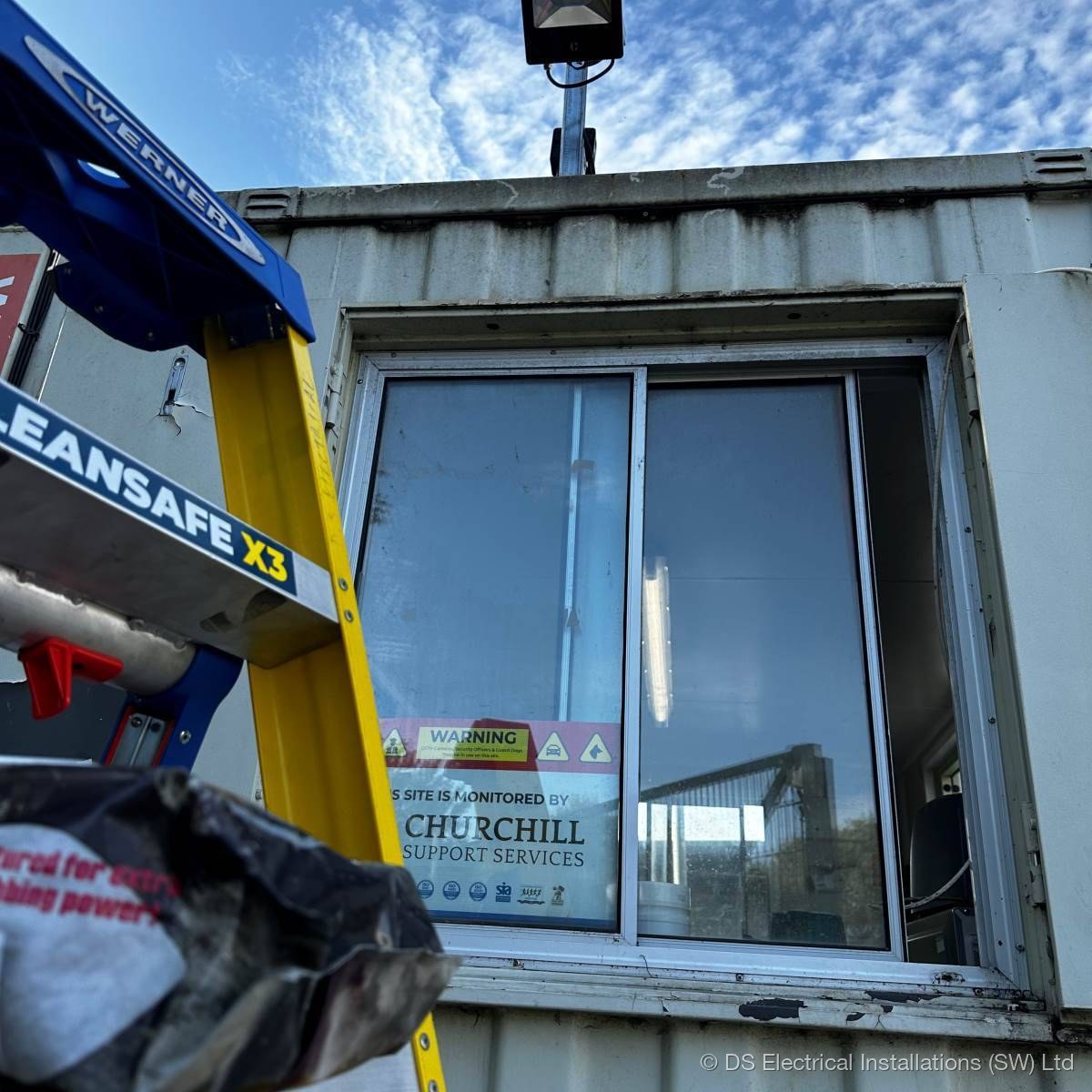 Pair of turret CCTV cameras fixed to internal steel roof beams, commercial warehouse