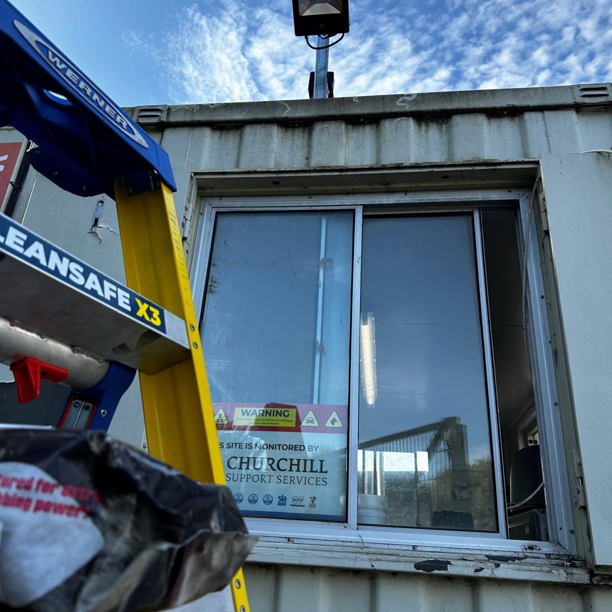 Pair of turret CCTV cameras fixed to internal steel roof beams, commercial warehouse