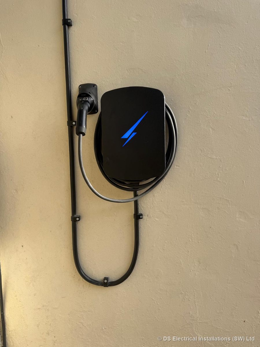 Wall-mounted tethered EV charger with the supply run in clipped conduit, installed by DS Electrical Installations (SW) Ltd