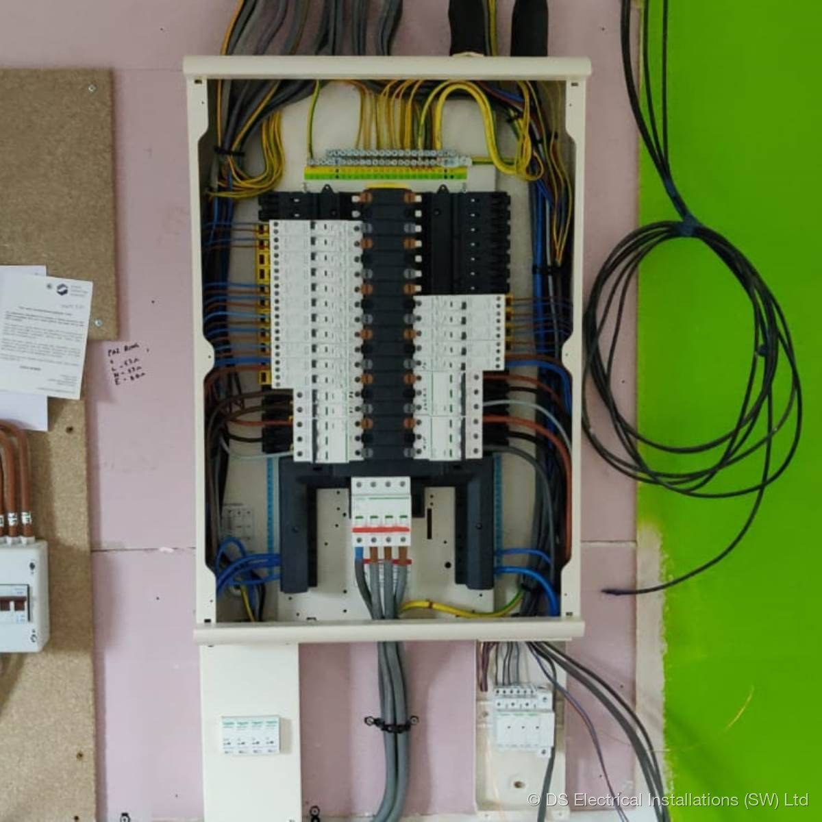 Commercial distribution board fully wired with banks of MCBs and RCBOs, neat colour-coded conductors and labelled circuits