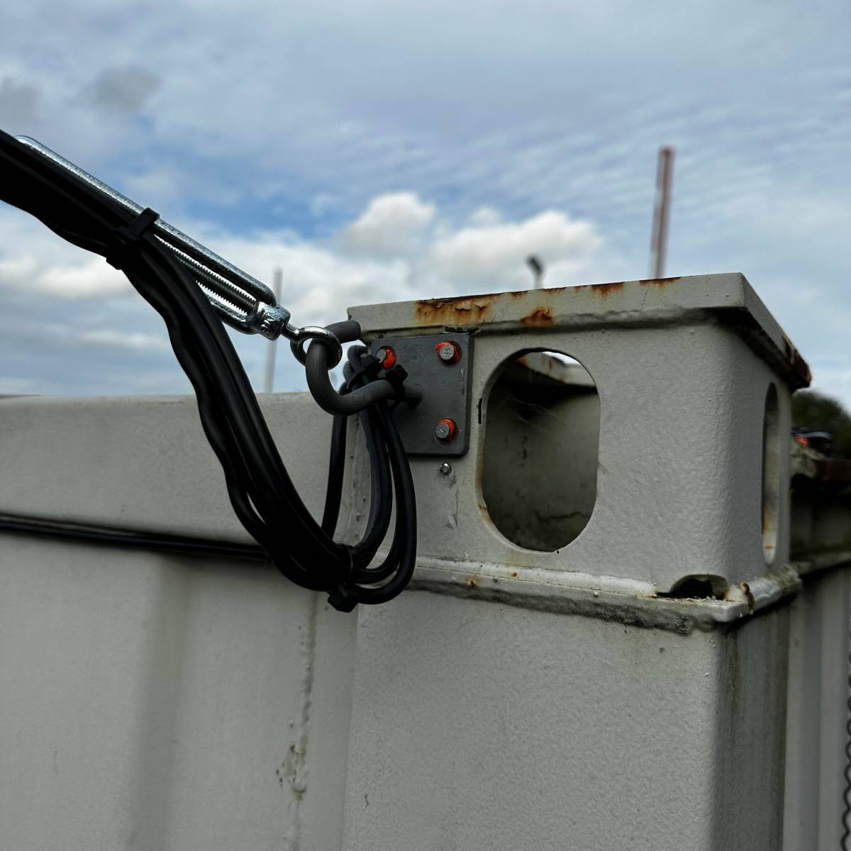 SWA armoured cable run secured to a galvanised steel post with a straining-wire turnbuckle, part of an external commercial supply by DS Electrical Somerset