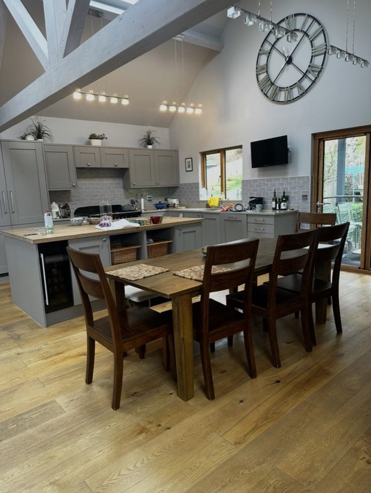 Vaulted ceiling kitchen with exposed white-painted beams and pendant lighting
