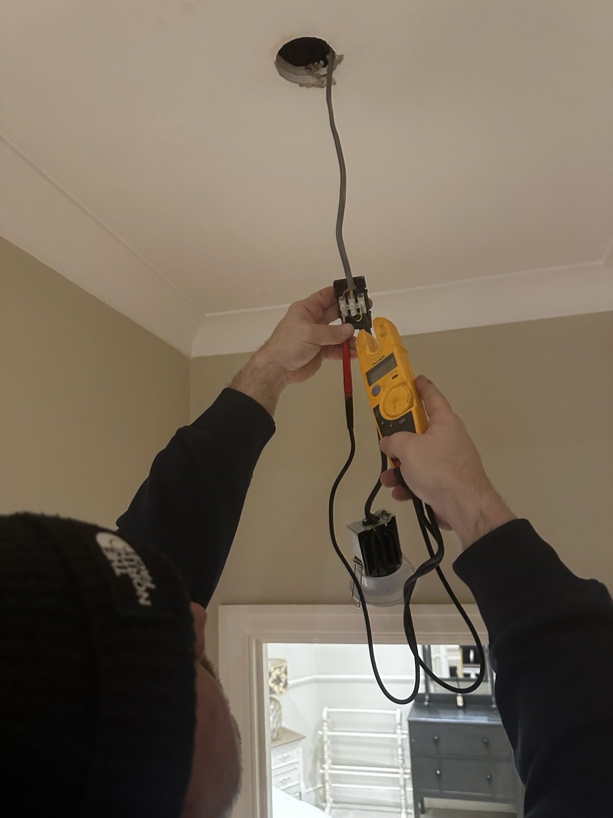 Engineer testing socket wiring with a Martindale voltage tester