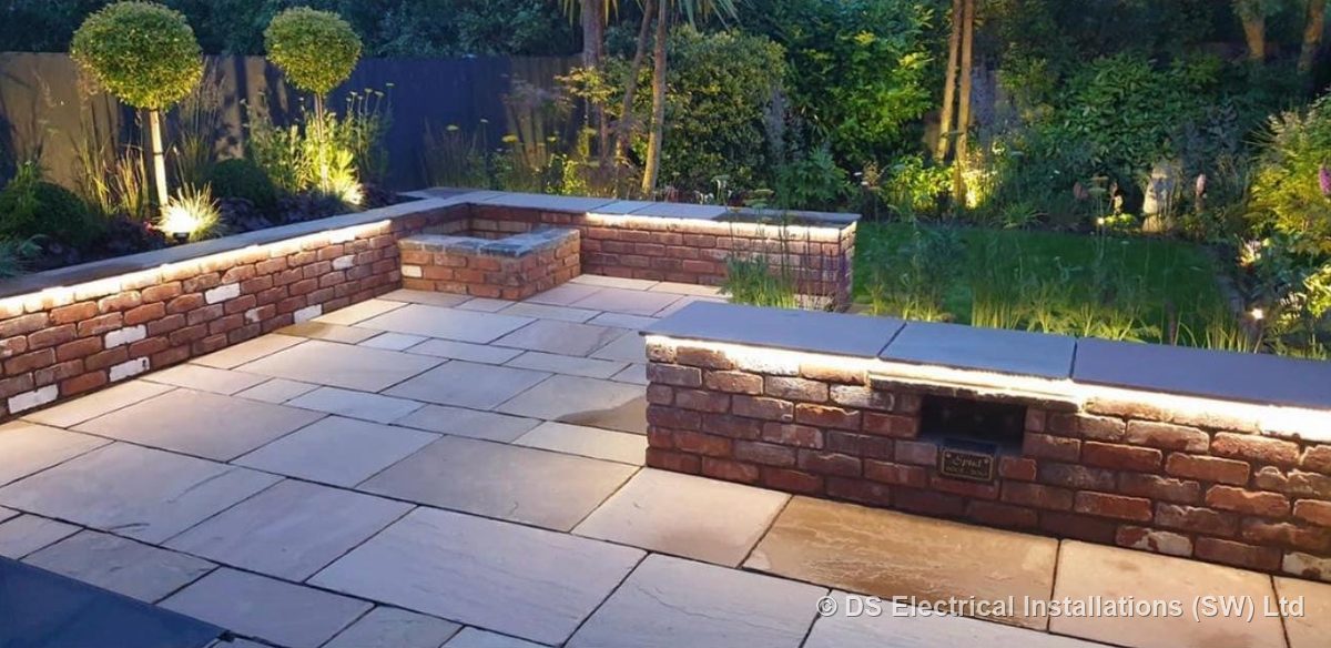 Patio walls lit with LED strip under the copings and spike lights through the planting, installed by DS Electrical Installations (SW) Ltd