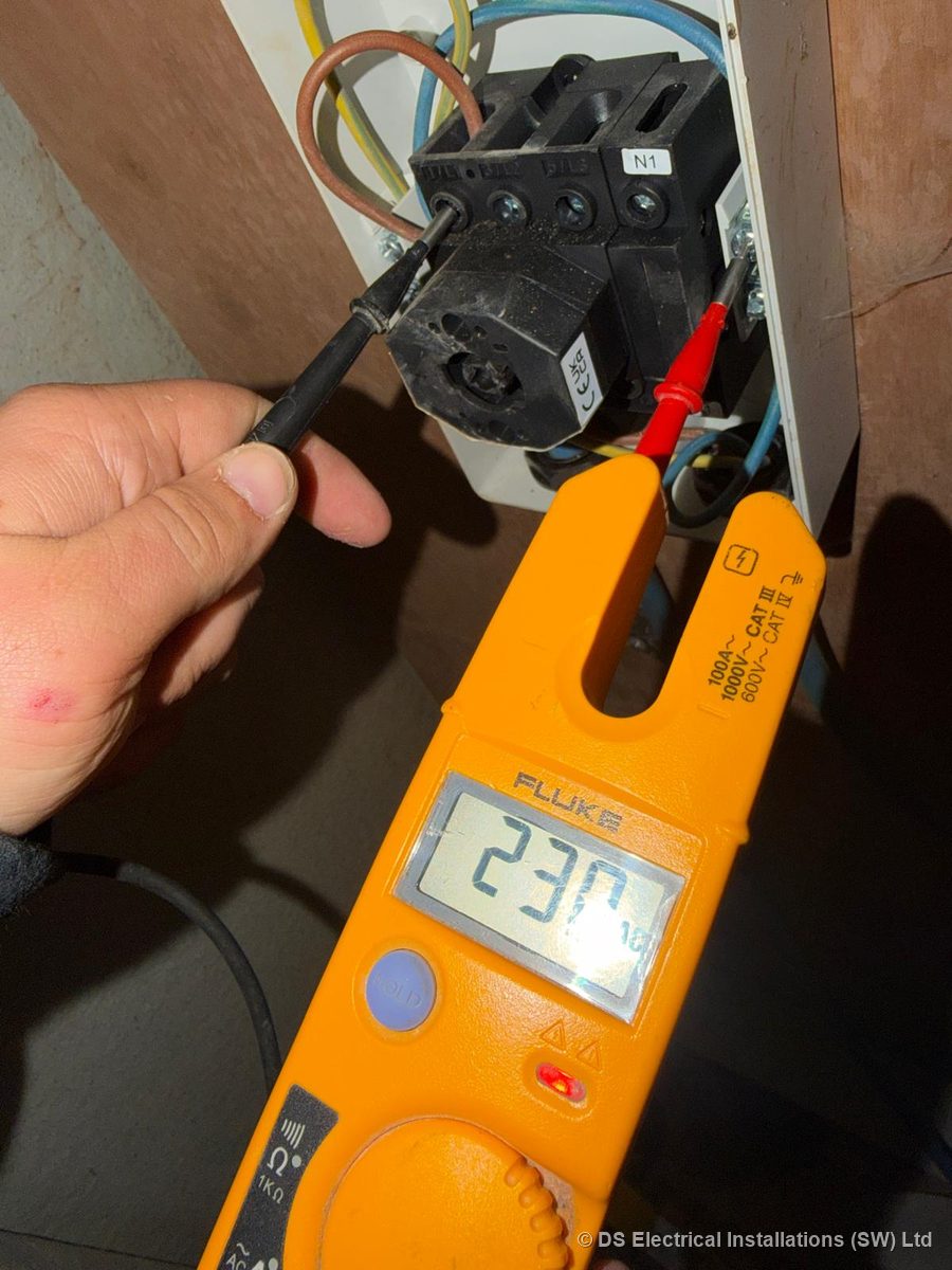 Proving the supply live at a rotary isolator with a voltage tester reading 230 V