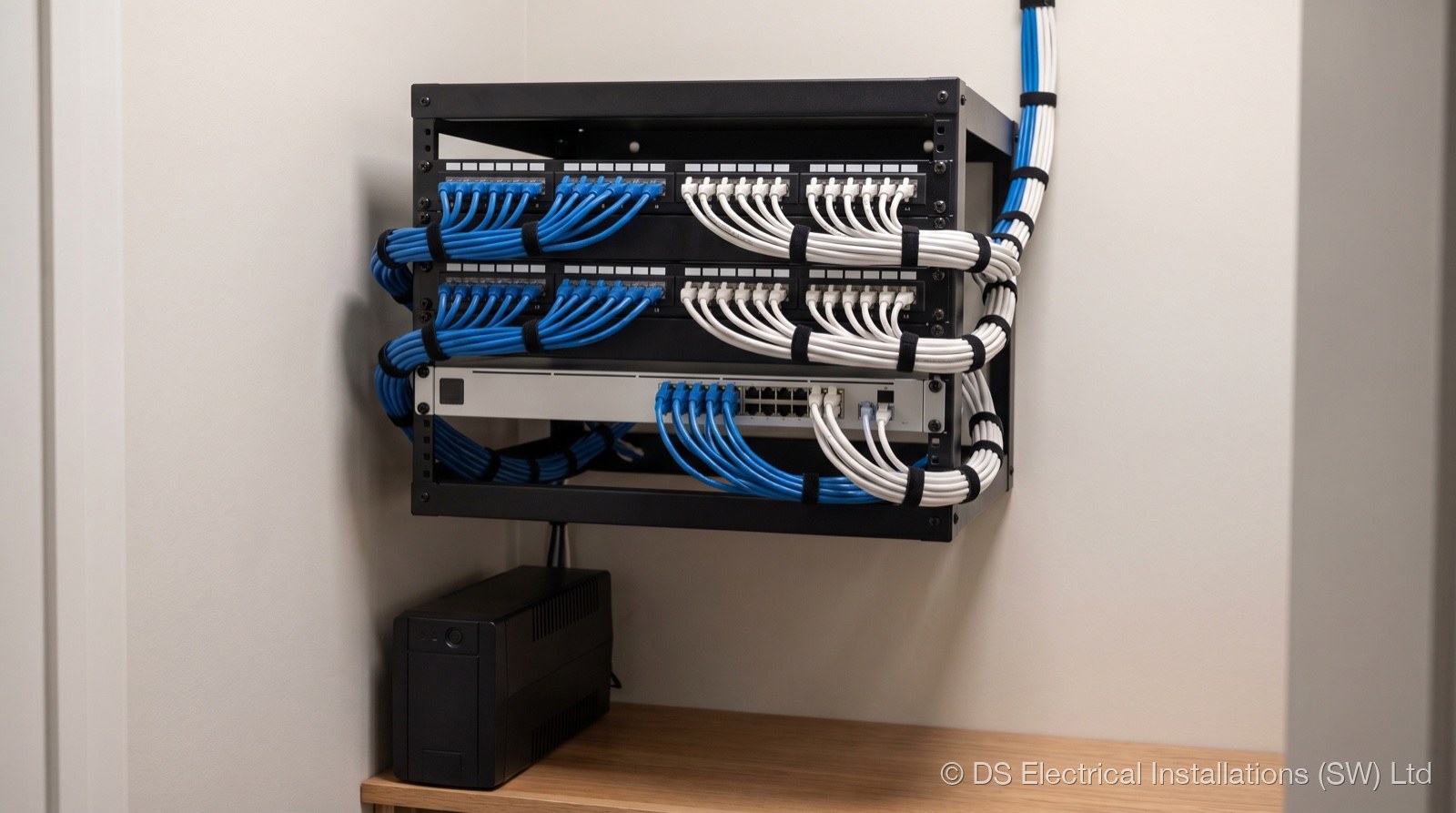 Wall-mounted Cat6 patch panel with dressed patch leads, installed by DS Electrical Installations (SW) Ltd