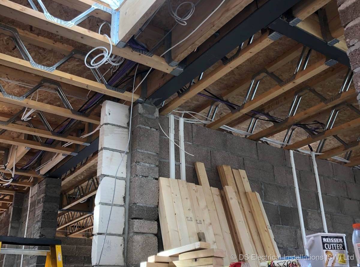 First-fix cables run through open ceiling joists during a renovation