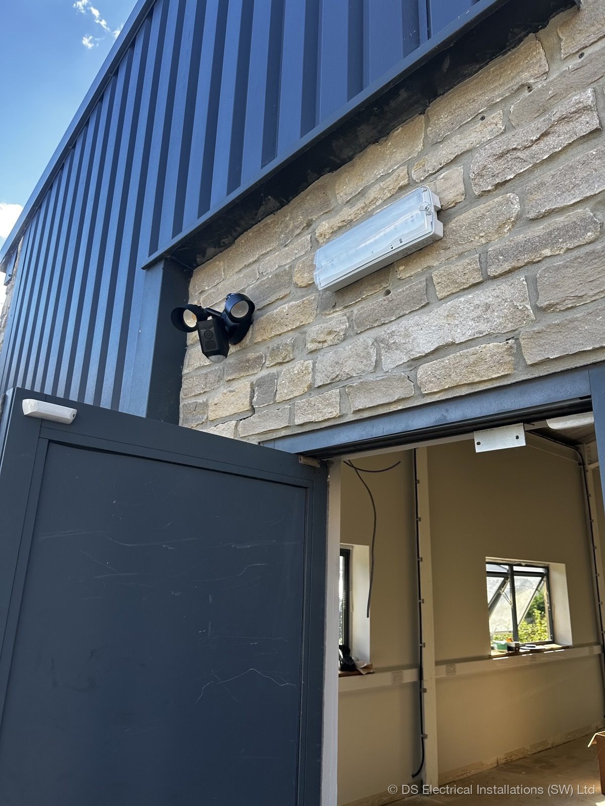 Security floodlight and emergency lighting on stone building