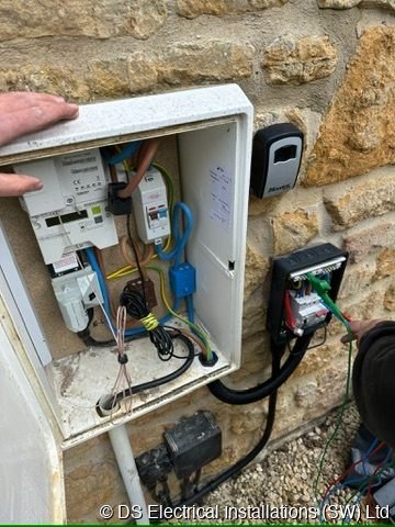Meter box opened on a stone wall showing the incoming supply equipment