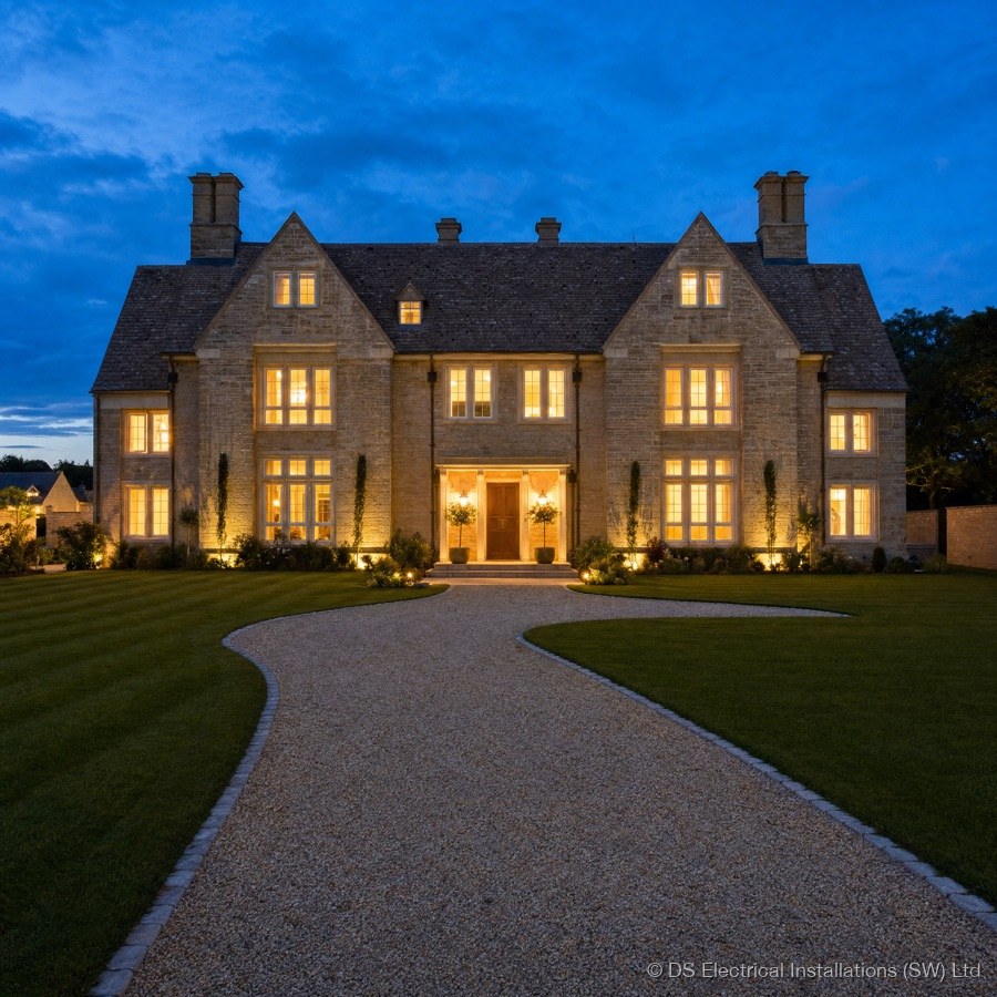 A country home lit up at dusk, representing landlord electrical safety reports